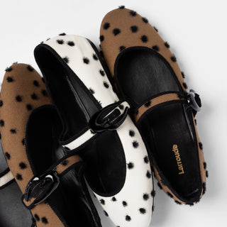 Larroudé Mary Jane flats in brown and white with black polka-dot texture and buckle straps, arranged on a white background.