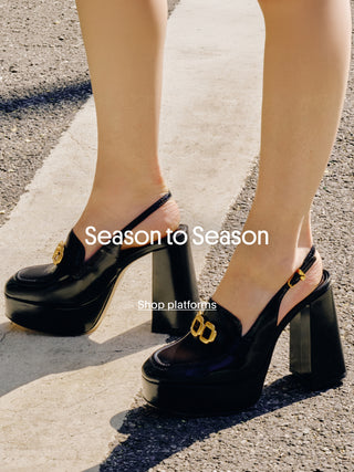 Close-up of a person wearing black patent platform slingback heels with gold hardware, standing on a sunlit sidewalk, with the text “Season to Season” and “Shop platforms” overlaid on the image.