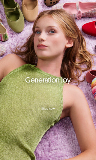 A young woman lying on a lavender rug, surrounded by colorful shoes, with the text “Generation Joy” and “Shop now” overlaid on the image